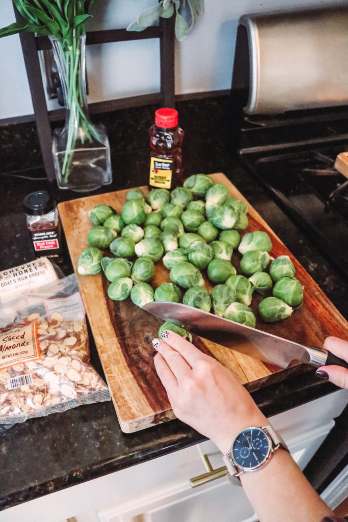 Honey Roasted Brussel Sprouts by popular Nashville life and style blog, Nashville Wifestyles: image of a woman cutting Brussel sprouts next to a Sue Bee honey bear.