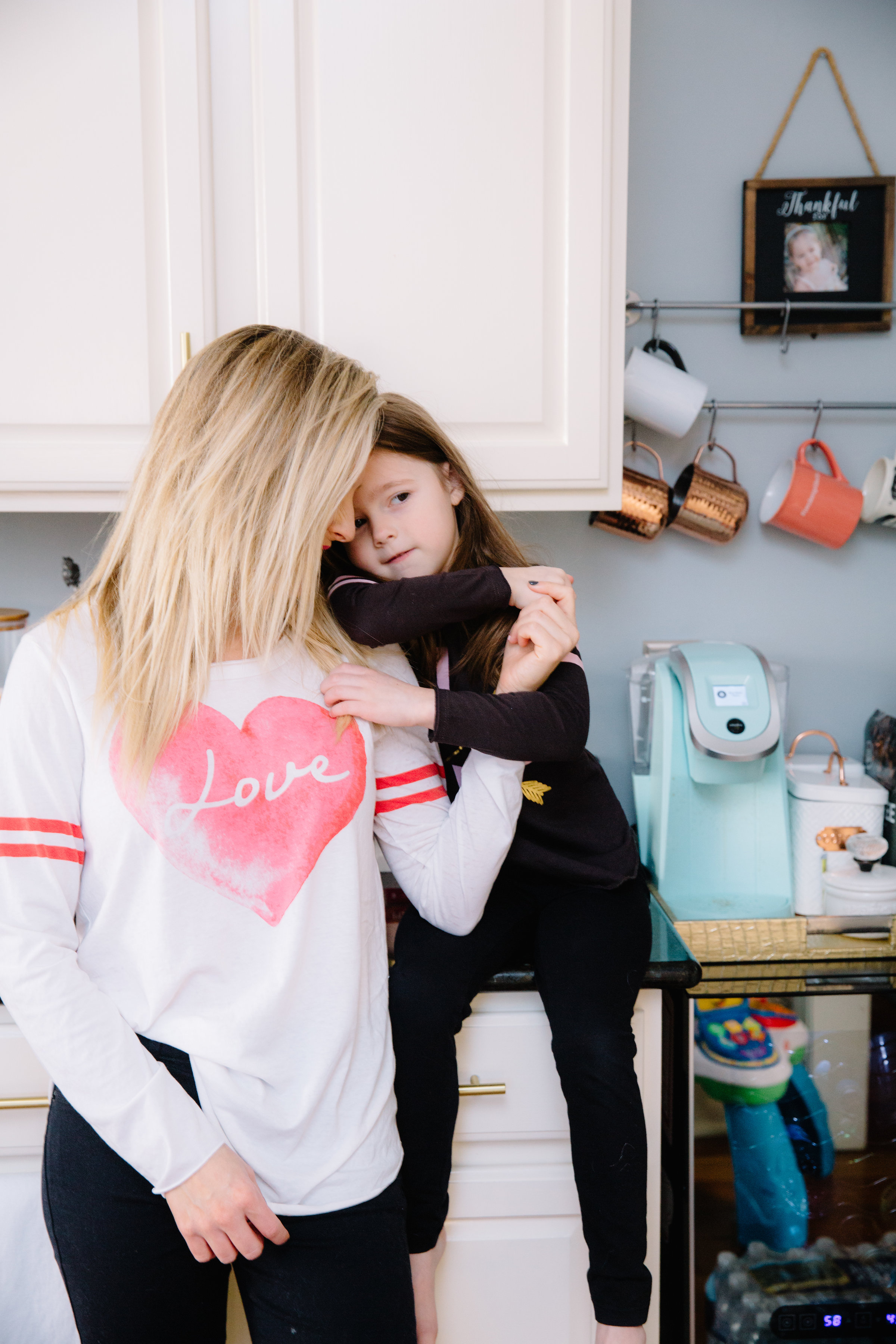 How Empaths can Help with Covid 19 by popular Nashville lifestyle blog, Nashville Wifestyles: image of a woman standing next to her daughter who is sitting on the kitchen counter.