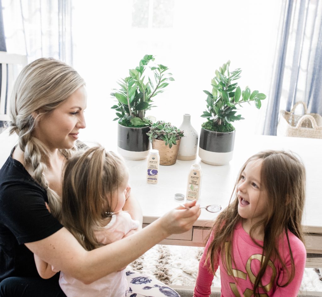 Immune Boosting Recipes by popular Nashville lifestyle blog, Nashville Wifestyles: image of a mom giving her daughter a spoonful of Marty's immune boosters. 