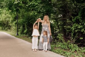 Coping Skills for Kids by popular Nashville motherhood blog, Nashville Wifestyles: image of a mom wearing a black and white jumpsuit while standing next to her daughters outside who are wearing a black and white polka dot romper and a black and white stripe top with white pants.