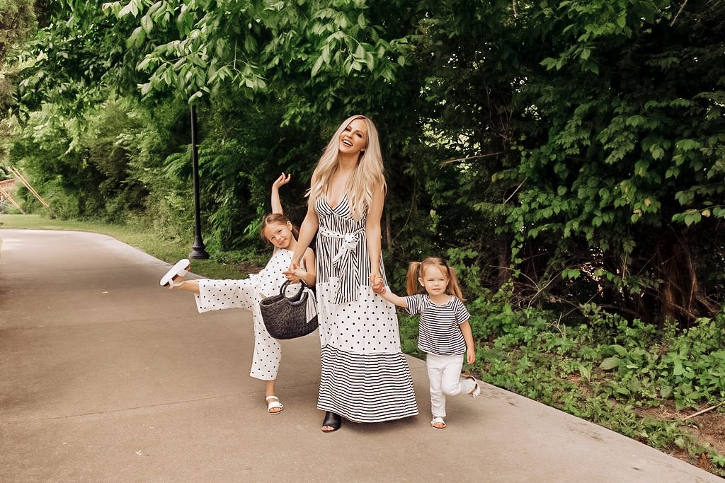 Coping Skills for Kids by popular Nashville motherhood blog, Nashville Wifestyles: image of a mom wearing a black and white stripes and polka dot dress while standing next to her daughters outside who are wearing a black and white polka dot romper and a black and white stripe top with white pants. 