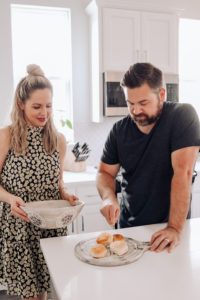 Date Night In Ideas by popular Nashville lifestyle blog, Nashville Wifestyles: image of a man and woman making food together in their kitchen.