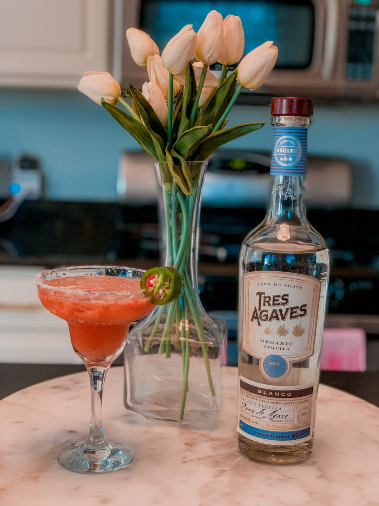 Skinny Margarita Recipe by popular Nashville lifestyle blog, Nashville Wifestyles: image of Tres Agaves liquor next to a spicy strawberry-jalapeno skinny margarita.