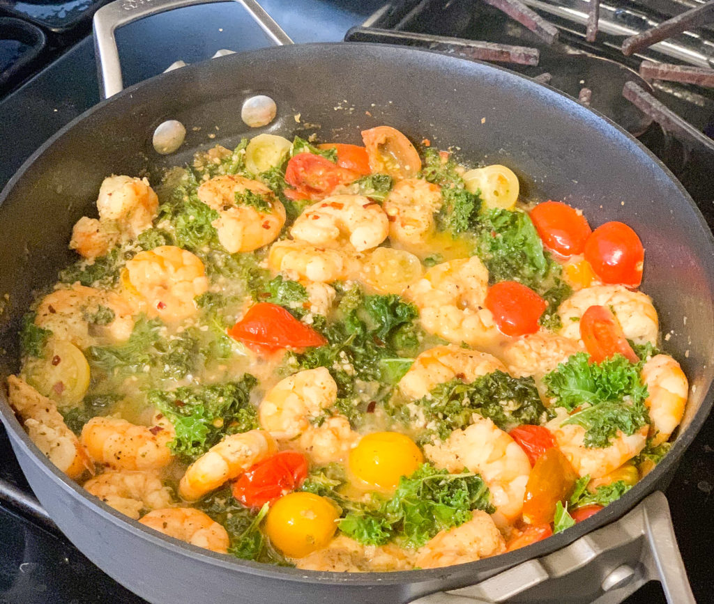 Gluten Free Shrimp Scampi by popular Nashville lifestyle blog, Nashville Wifestyles: image of some shrimp and tomatoes cooking in a pan on the stove. 
