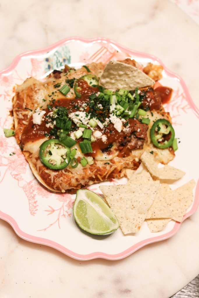 Healthy Beef Enchiladas by popular Nashville lifestyle blog, Nashville Wifestyles: image of a some healthy beef enchiladas and tortilla chips on a pink and white floral plate. 