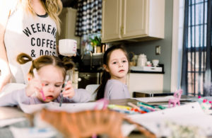 Homemade Mothers Day Gifts From Child by popular Nashville lifestyle blog, Nashville Wifestyles: image of a mom sitting at a farmhouse table with her two daughters while they work on some crafts.