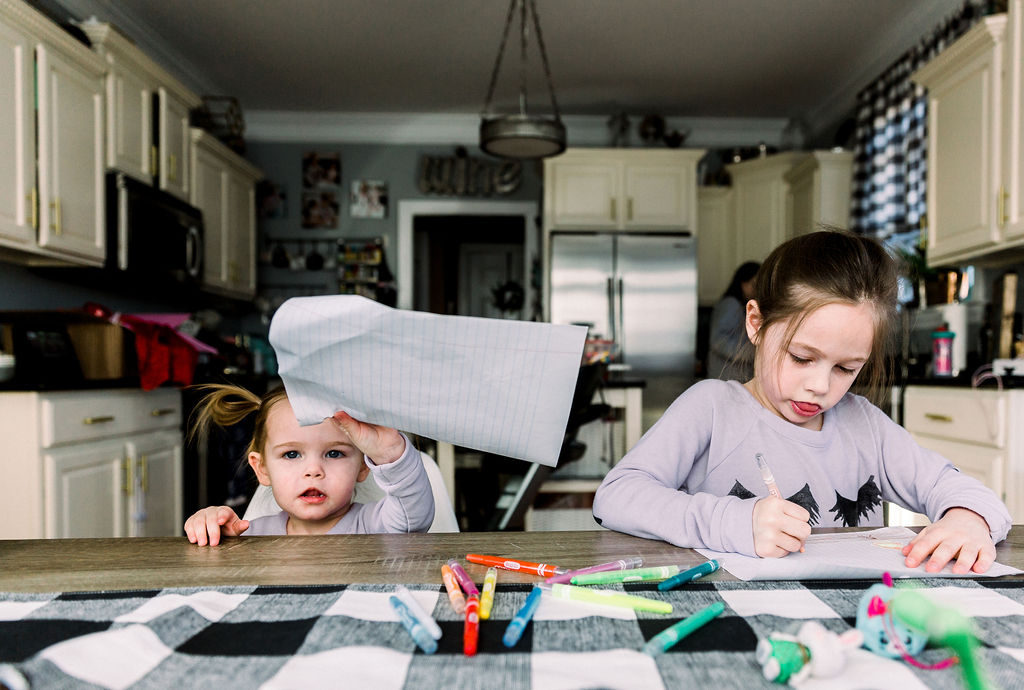 Homemade Mothers Day Gifts From Child by popular Nashville lifestyle blog, Nashville Wifestyles: image of two girls sitting at a farmhouse table while they work on some crafts. 