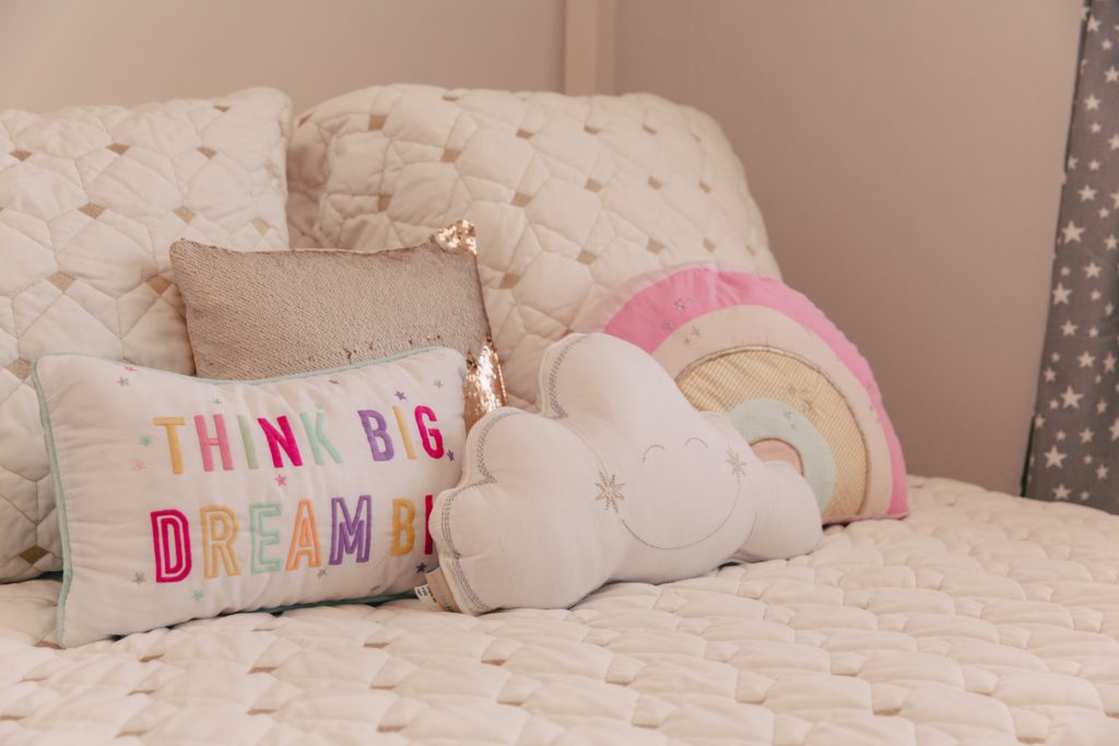 Toddler Room by popular Nashville motherhood blog, Nashville Wifestyles: image of a toddler room decorated with a Pottery Barn Kids Camden House Bed, Pottery Barn Kids Coco Quilt, and Pottery Barn Kids Retro Rainbow Shaped Pillow.