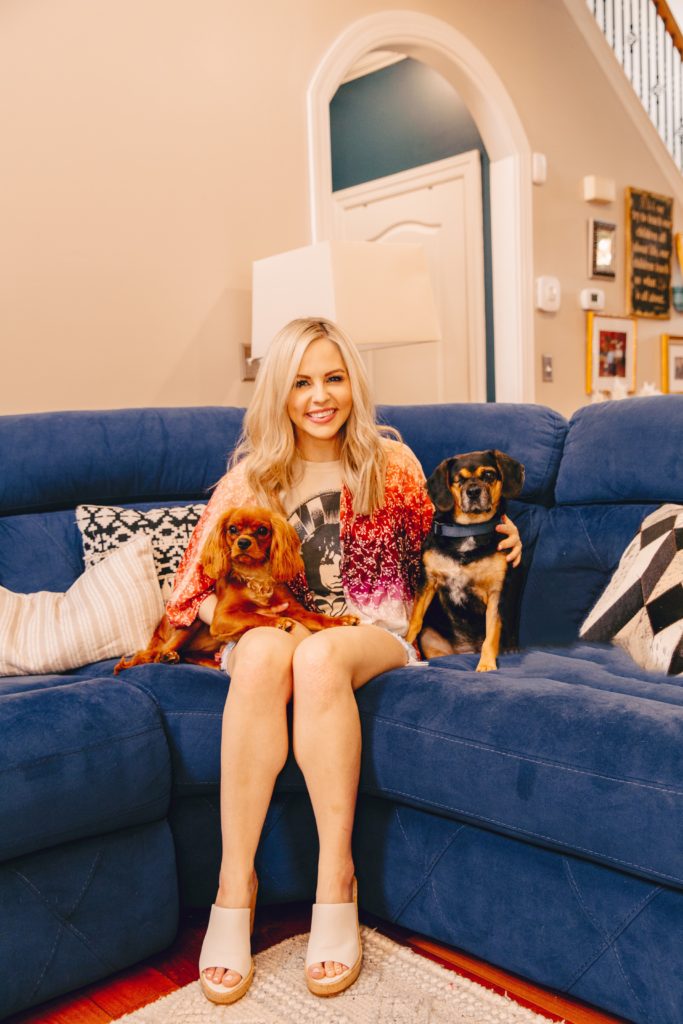 Pet Parent by popular Nashville lifestyle blog, Nashville Wifestyles: image of a woman sitting sitting on a blue couch with her two dogs. 