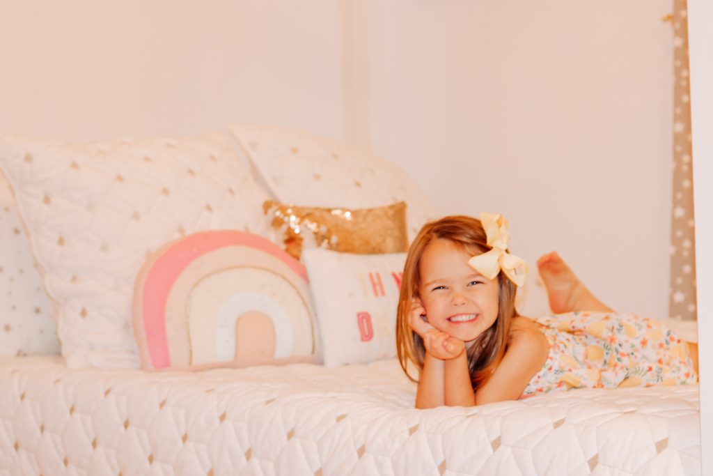 Toddler Room by popular Nashville motherhood blog, Nashville Wifestyles: image of a little girl laying on her bed. 