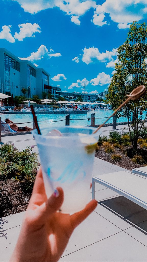 Soundwaves Water Park by popular Nashville blog, Nashville Wifestyles: image of a woman holding a mixed drink in front of a pool. 