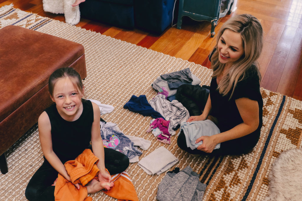 Chores for Kids by popular Nashville motherhood blog, Nashville Wifestyles: image of a young girl helping her mom sort laundry. 