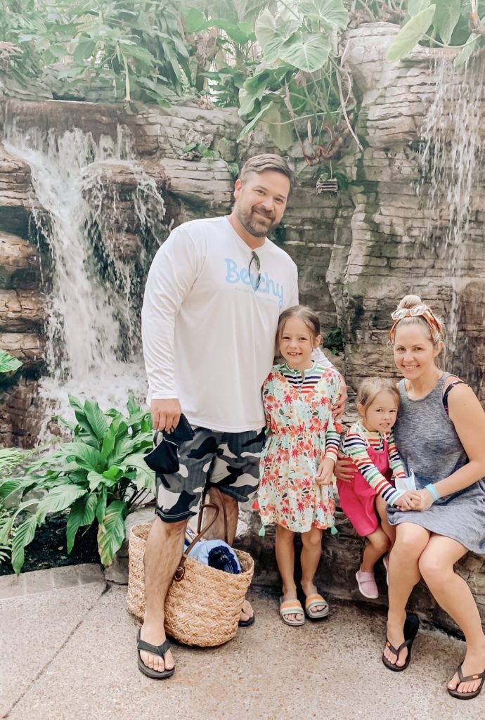 Soundwaves Water Park by popular Nashville blog, Nashville Wifestyles: image of a family sitting together in front of a indoor waterfall. 