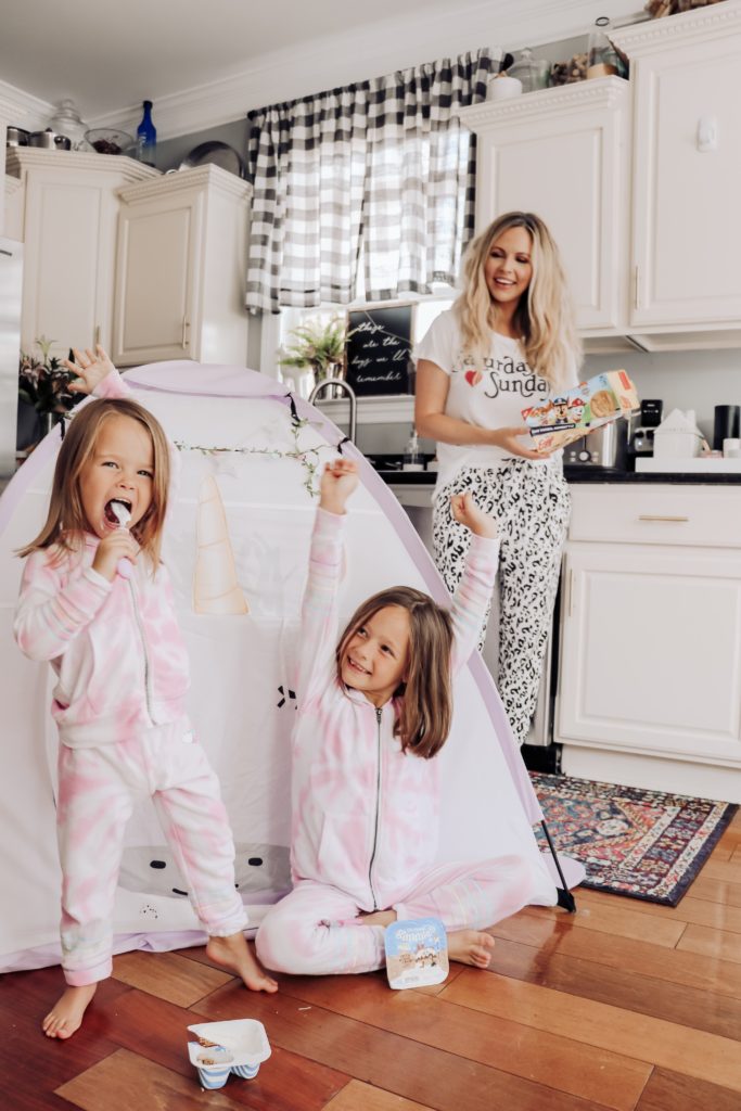 Things to do in the Summer by popular Nashville lifestyle blog, Nashville Wifestyles: image of two young girls wearing matching sweatsuits and playing in a tent in their kitchen. 