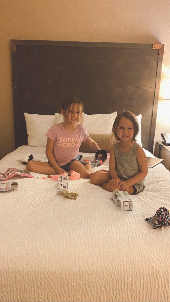 Pigeon Forge TN by popular Nashville travel blog, Nashville Wifestyles: image of two young girls sitting on a bed in their room at the Black Fox Lodge. 