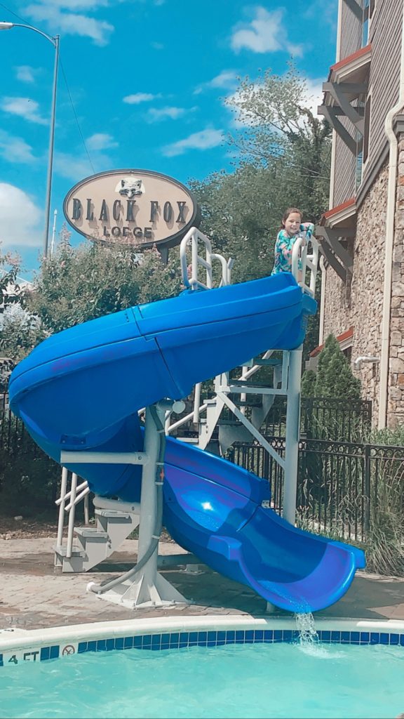 Pigeon Forge TN by popular Nashville travel blog, Nashville Wifestyles: image of a girl on a outdoor waterslide at the Black Fox Lodge. 