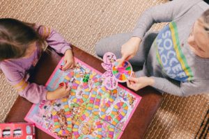 Family Board Games by popular Nashville motherhood blog, Nashville Wifestyles: image of a woman playing Candyland with her daughter.