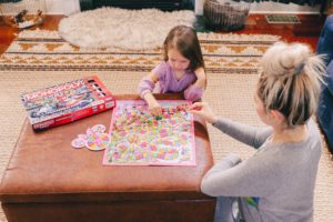 Family Board Games by popular Nashville motherhood blog, Nashville Wifestyles: image of a woman playing Candyland with her daughter.