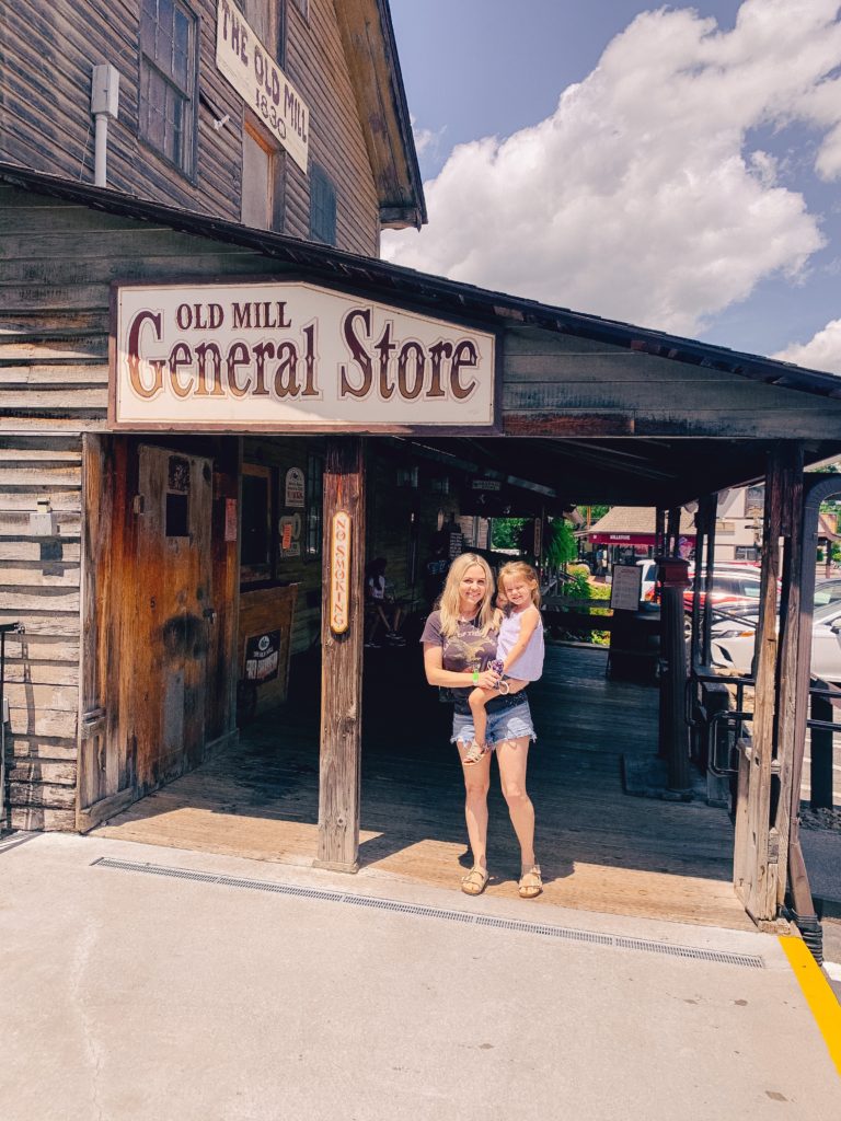 Pigeon Forge TN by popular Nashville travel blog, Nashville Wifestyles: image of a mom holding her daughter in front of the Old Mill General Store. 