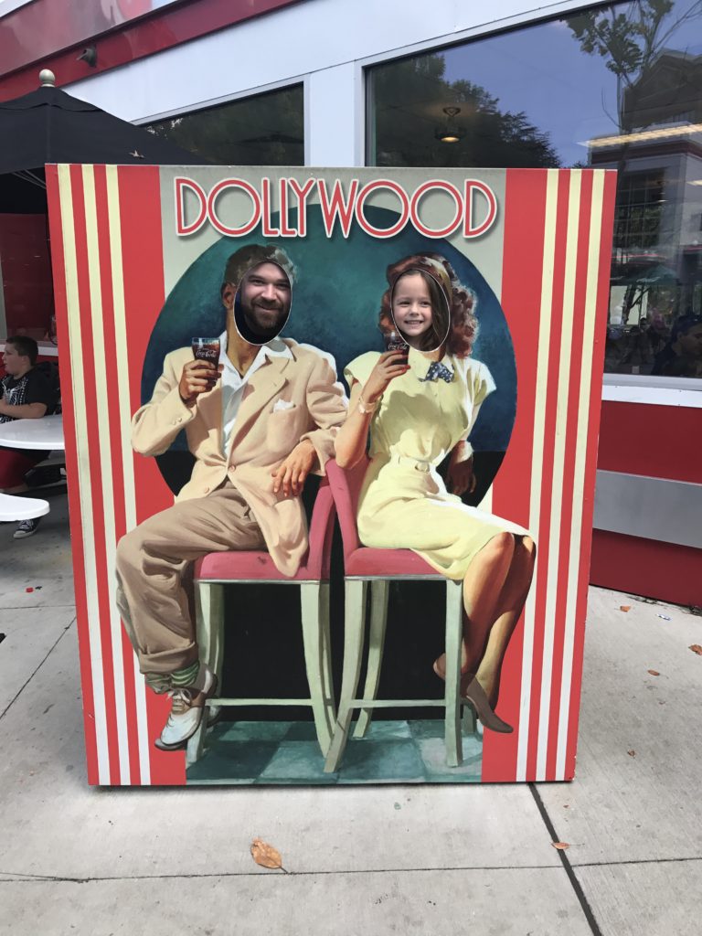 Pigeon Forge TN by popular Nashville travel blog, Nashville Wifestyles: image of a dad and his daughter posing behind a Dollywood cutout. 