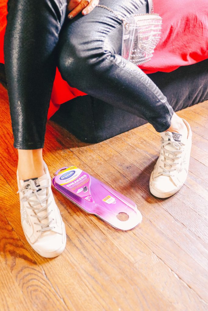 How to Relieve Sore Feet by popular Nashville lifestyle blog, Nashville Wifestyles: image of a woman putting on a pair of sneakers next to a package of Dr. Scholl's inserts. 