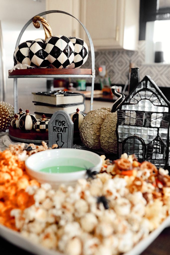 Halloween Snack Ideas by popular Nashville lifestyle blog, Nashville Wifestyles: image of a kitchen counter decorated with Mackenzie Childs Halloween decor and a serving tray filled with popcorn. 