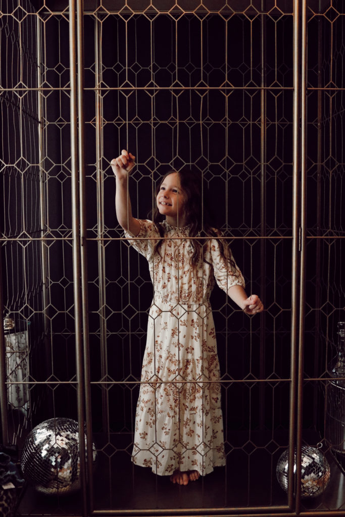 Strong Willed Child by popular Nashville motherhood blog, Nashville Wifestyles: image of a little girl wearing a floral maxi dress and standing next to some disco balls. 