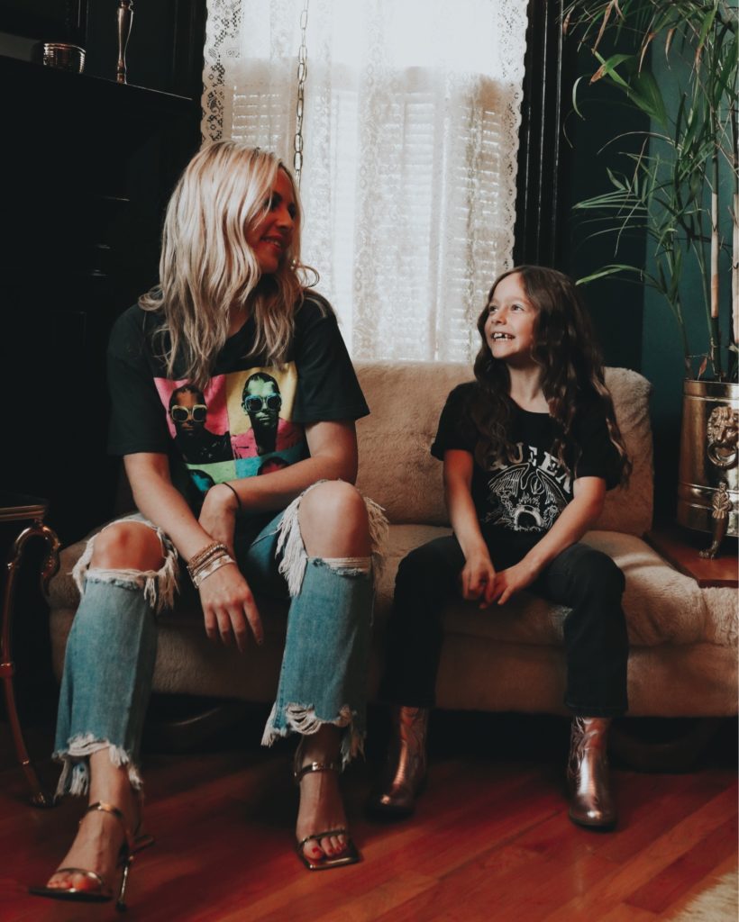 Strong Willed Child by popular Nashville motherhood blog, Nashville Wifestyles: image of a mom and daughter wearing band tees and sitting together on a faux fur couch. 