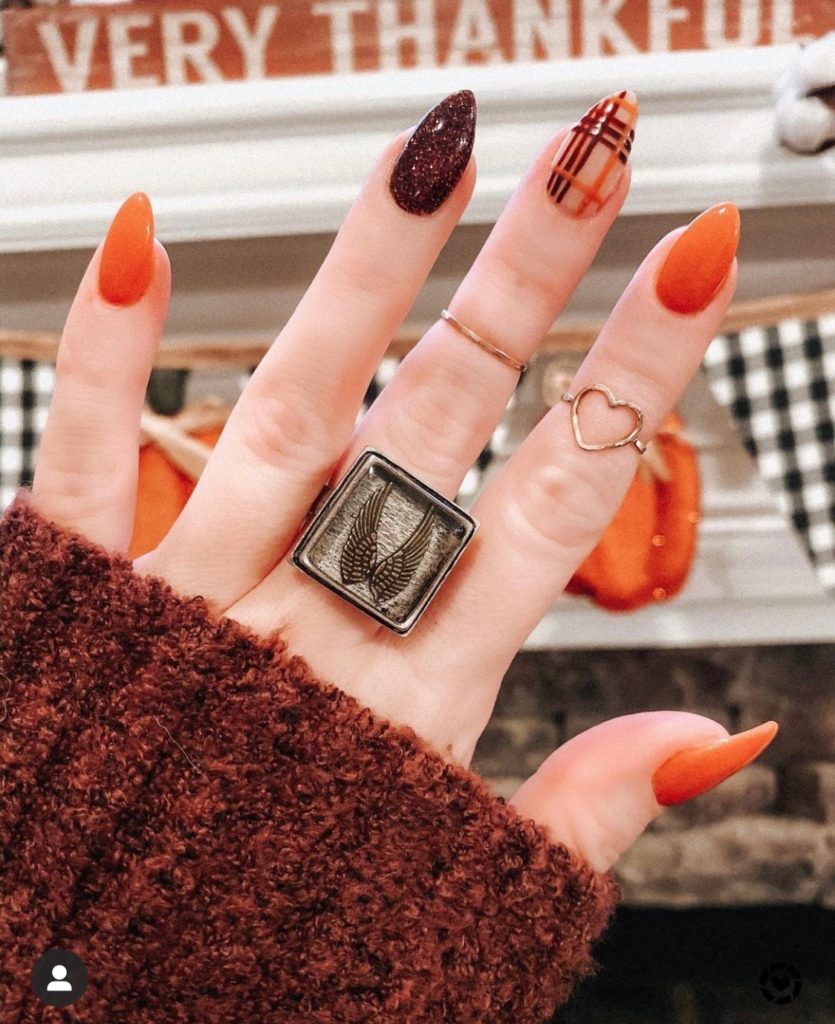 Nail Trends by popular Nashville beauty blog, Nashville Wifestyles: image of a woman with a orange and maroon manicure with a plaid accent nail. 