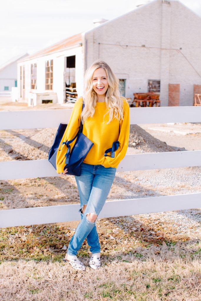 Tote Bags by popular Nashville fashion blog, Nashville Wifestyles: image of a woman wearing a yellow sweater, distressed denim and carrying a blue tote bag. 