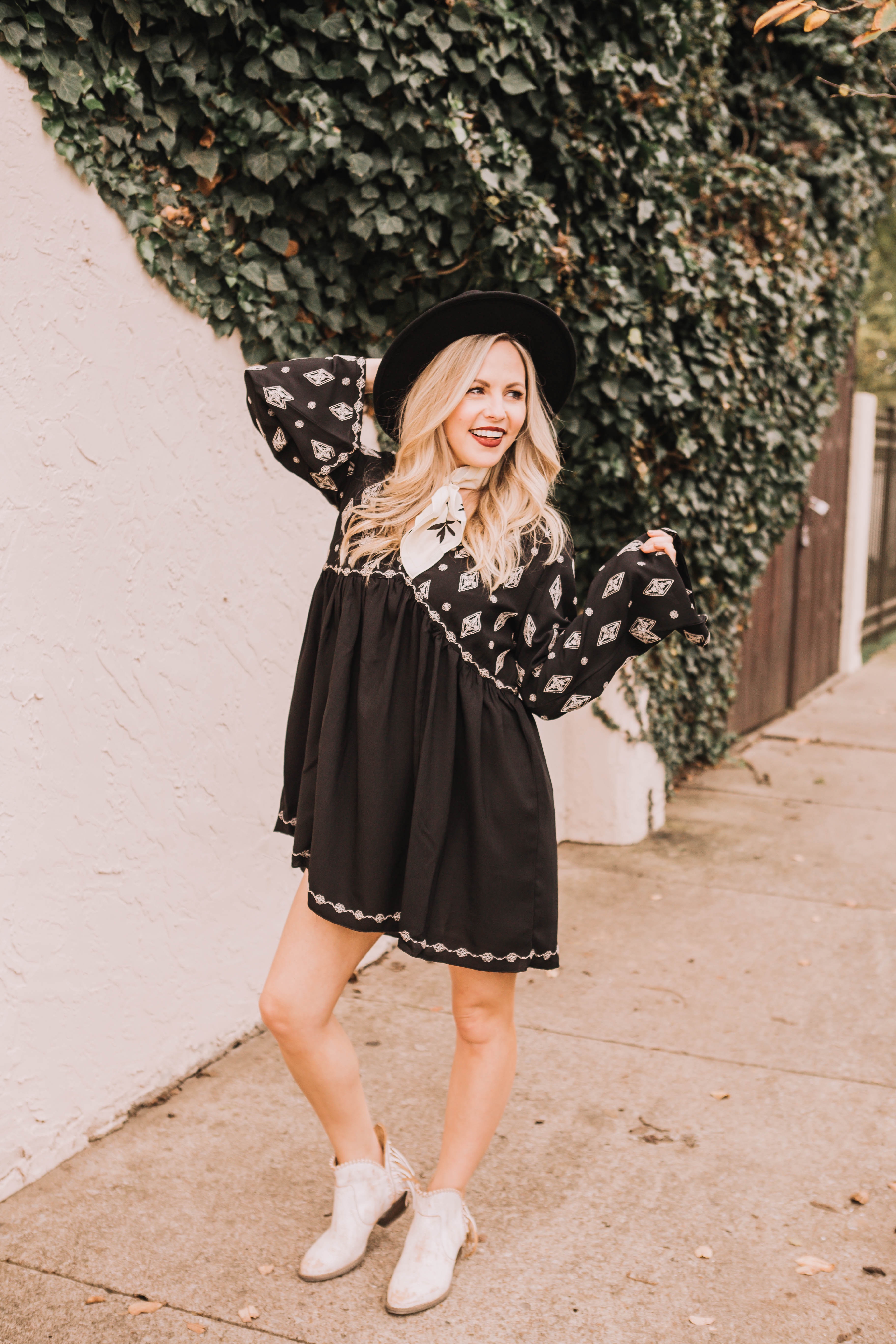 Cowboy Boots for Women by popular Nashville fashion blog, Nashville Wifestyles: image of a woman wearing a black and white mini dress, white bandana tied around her neck, black felt hat and white cowboy ankle boots.