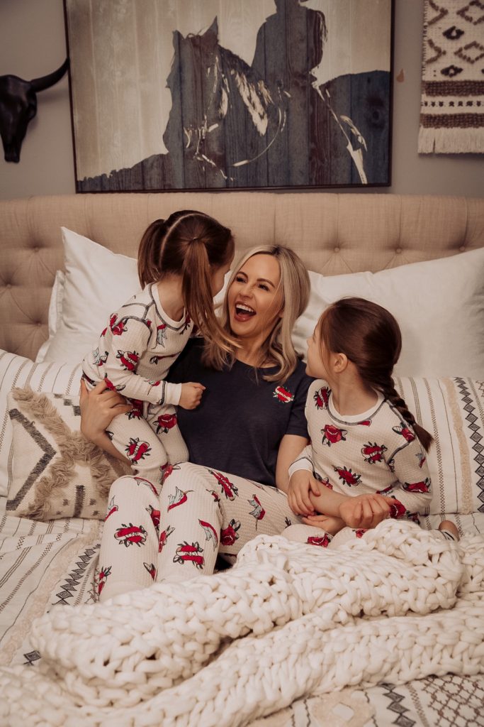 Hoffmann Brothers Home Protection Plan by popular Nashville lifestyle blog, Nashville Wifestyles: image of a mom and her two young daughters sitting in bed and wearing matching pajamas. 