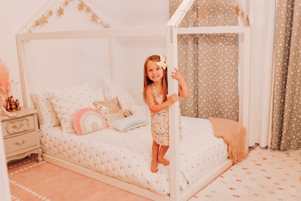 Toddler Floor Bed by popular Nashville motherhood blog, Nashville Wifestyles:  image of a little girl standing on her house frame toddler floor bed. 