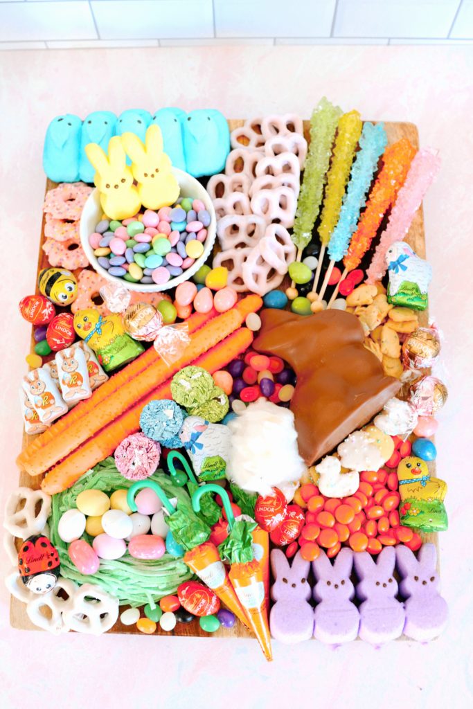 Easter Charcuterie Board Ideas by popular Nashville lifestyle blog, Nashville Wifestyles: image of a Easter charcuterie board with Peeps, strawberry yogurt dipped pretzels, rock candy suckers, chocolate bunnies, jelly beans, and chocolate candy. 