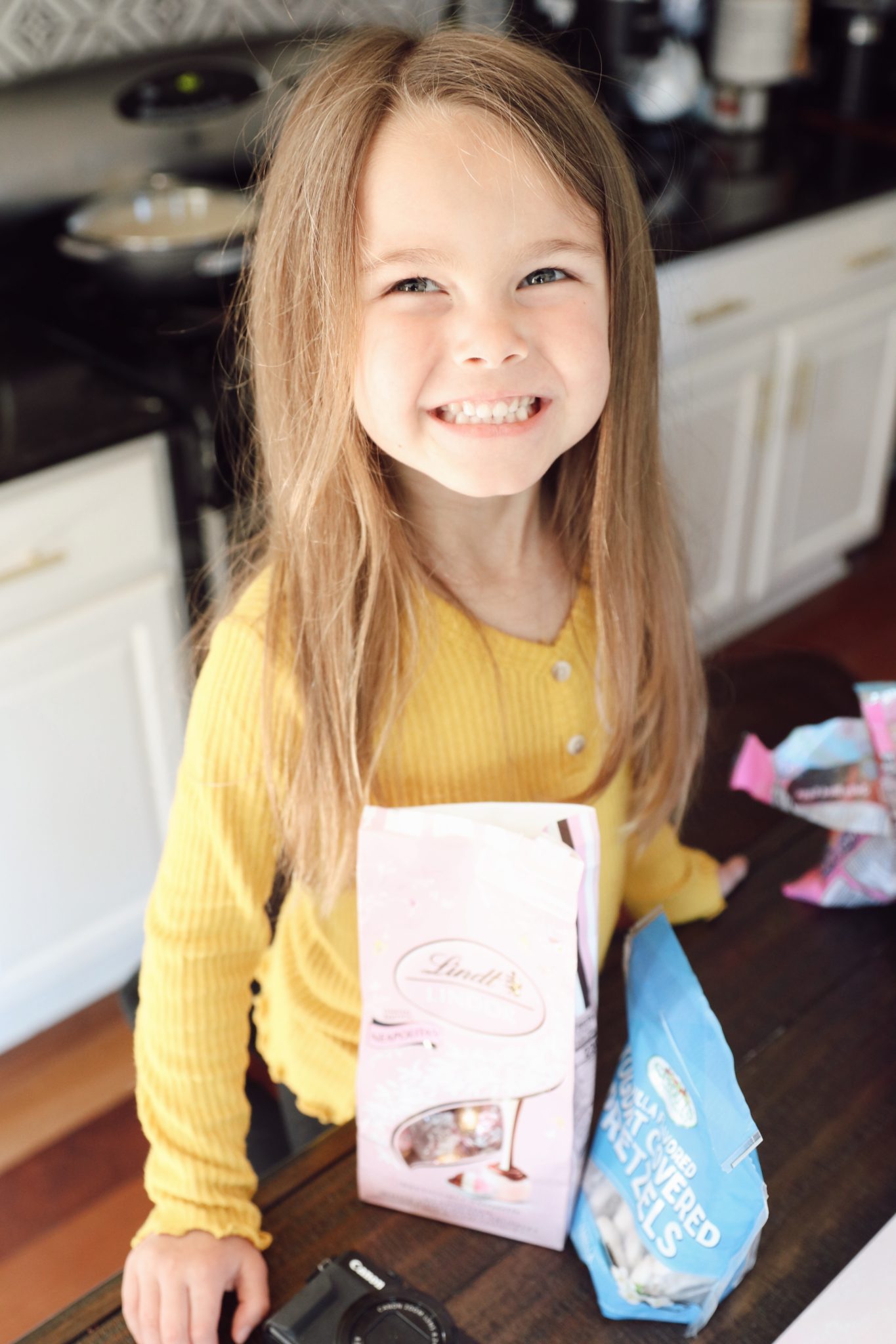 Easter Charcuterie Board Ideas by popular Nashville lifestyle blog, Nashville Wifestyles: image of a little girl standing next to some bags of Lindt chocolates.