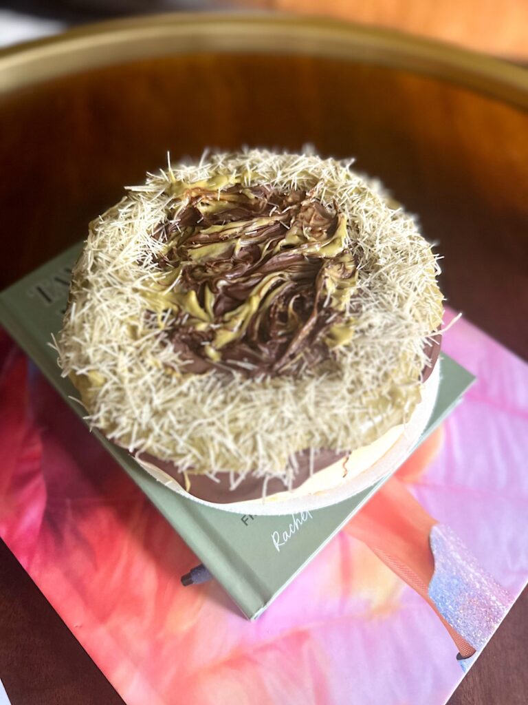 Store-bought cheesecake topped with melted chocolate, pistachio paste, and kataifi in a Dubai chocolate–inspired style.