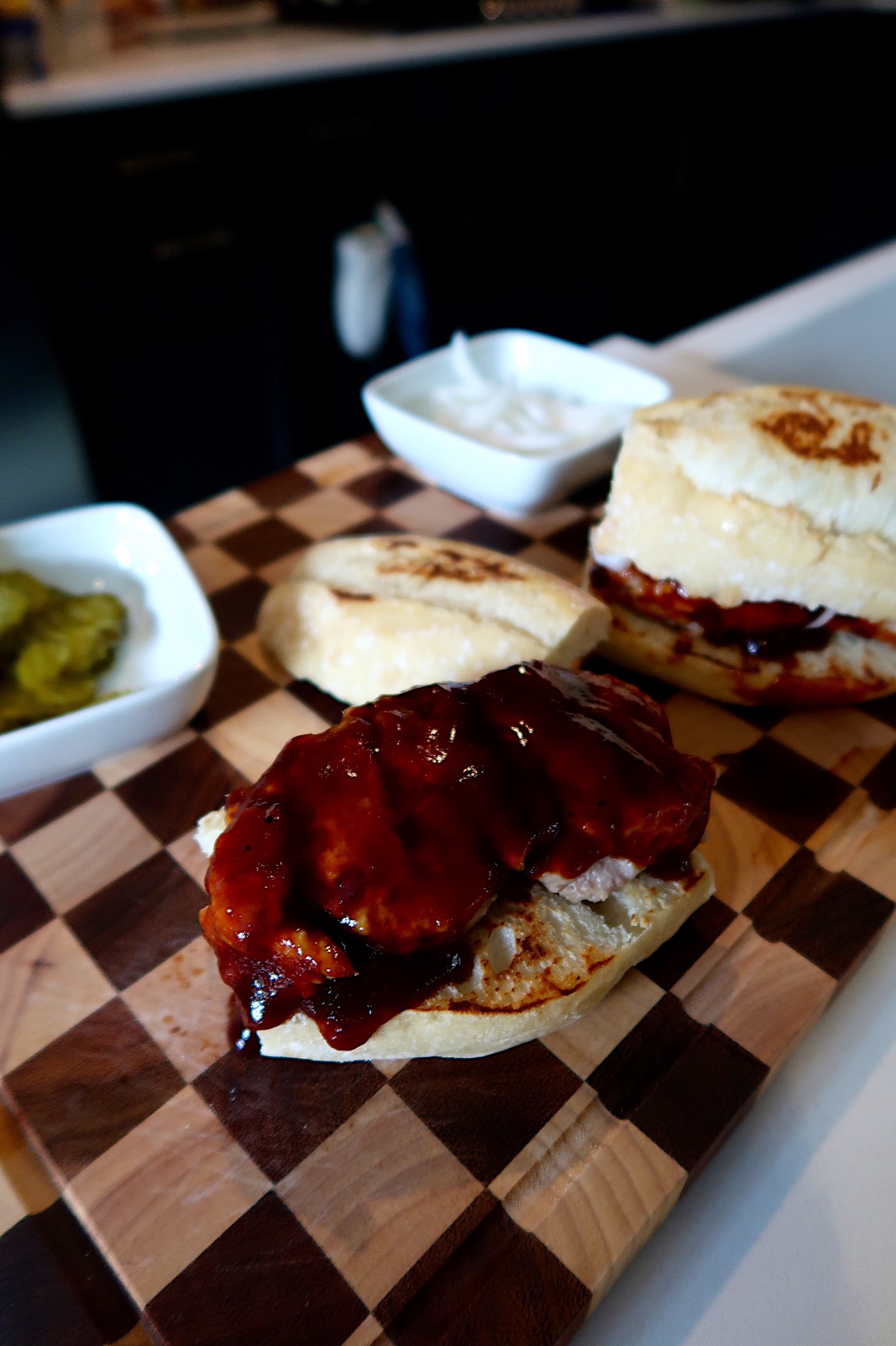 Homemade K-Rib sandwich with BBQ sauce, pickles, and onions